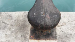 Texture d’une bite d’amarrage rouillée sur un quai de port – Photographie maritime de François Bouthors