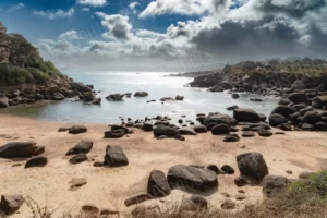 Plage de Bretagne avec rochers et ciel nuageux – photographie de paysage par François Bouthors