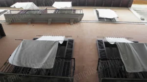 Photographie d’architecture montrant une façade urbaine avec des draps blancs suspendus aux fenêtres, réalisée par François Bouthors.