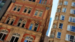 Photographie d’architecture de façades urbaines contrastées, mêlant brique rouge et immeuble contemporain.