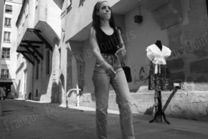 Photographie de rue en noir et blanc d’une femme marchant dans une ruelle urbaine, scène captée sur le vif par François Bouthors.