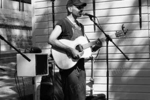 Photo de rue en noir et blanc d’un musicien jouant de la guitare dans la lumière urbaine – François Bouthors