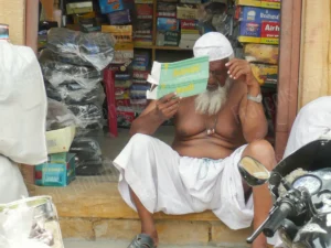 Photographie portrait d’un homme lisant dans sa boutique en Inde – François Bouthors