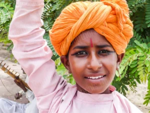 Photographie de portrait d’un jeune homme indien au turban orange en extérieur, par François Bouthors