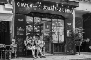 Street photo en noir et blanc de jeunes assis devant une chocolaterie en centre-ville – François Bouthors